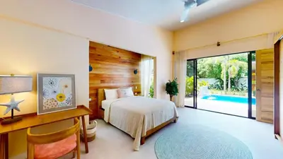 a bedroom with a bed and a desk and a bed sidx sidx sidx at Casa Luna Rosa in Uvita