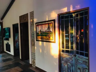 a wall with a painting of a boat on it at Casa Bali in San Francisco de Palmera