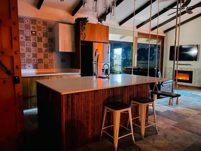 a kitchen with a large island with two bar stools at Casa Bali in San Francisco de Palmera