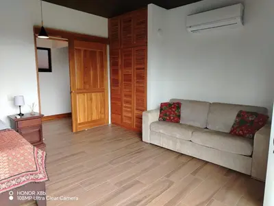 a living room with a couch and a wooden door at Hacienda las colinas in Mesas