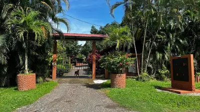 a gate to a house with palm trees at Hacienda las colinas in Mesas