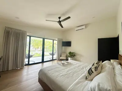 a bedroom with a large bed with a ceiling fan at Luxury Beachfront in Playa Tivives, Puntarenas with Ocean Views,Pool in Tivives