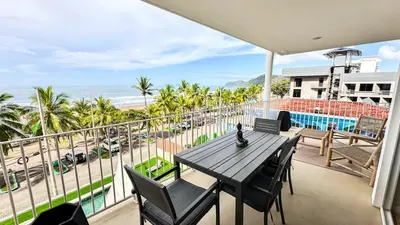 a balcony with a table and chairs and the beach at Pacific Point - Pure Vida in Jaco, Costa Rica in Jacó