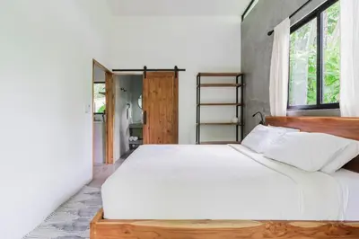 a bedroom with a large white bed and a window at Casa con piscina privada a 700 m de Playa de Santa Teresa in Santa Teresa Beach