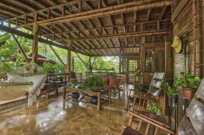 a room with a hammock and tables and plants at Casa Alma, Nature Escape with River, Trails and Views