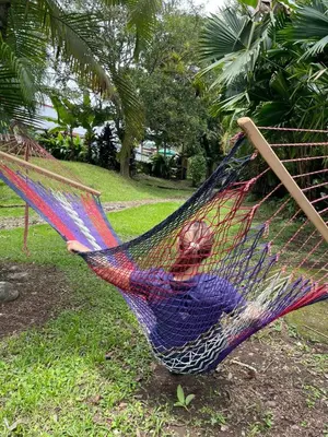 a person is laying in a hammock at Hotel Geliwa in Turrialba