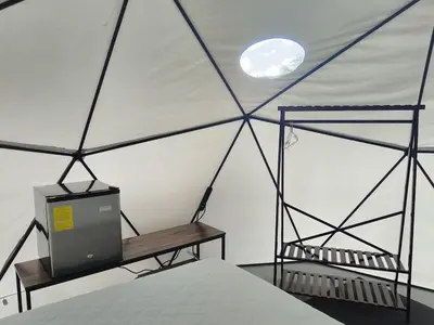 a room with a bed and a tv in a tent at Osaglamping in Palmar Norte
