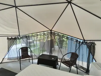 a room with two chairs and a bed in a tent at Osaglamping in Palmar Norte