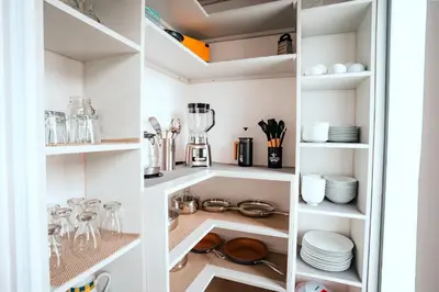 a walk in pantry with white shelves and dishes at Casa Dalia in Monteverde Costa Rica