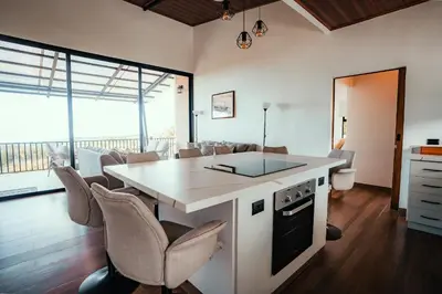 a kitchen with a island with a counter and chairs at Casa Dalia in Monteverde Costa Rica