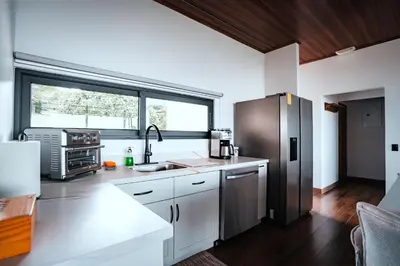 a kitchen with white cabinets and a stainless steel refrigerator at Casa Dalia in Monteverde Costa Rica