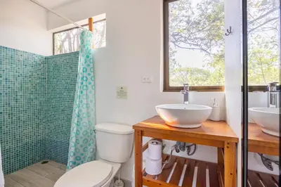 a bathroom with a toilet and a sink and a shower at La Buena vida Cabina 2 in Refundores