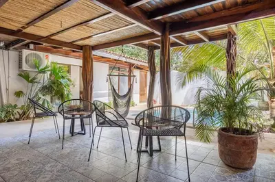 a patio with chairs and a palm tree at La Buena vida Cabina 2 in Refundores