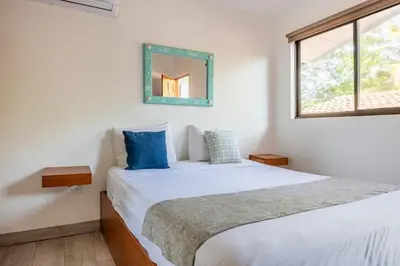 a bedroom with a white bed and a mirror at La Buena vida Cabina 2 in Refundores