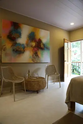 a room with two chairs and a table and a painting at Tekana Boutique Jungle Retreat in Tamarindo