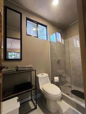 a bathroom with a toilet and a shower at Tekana Boutique Jungle Retreat in Tamarindo