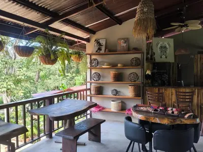a room with a balcony with tables and chairs at Tekana Boutique Jungle Retreat in Tamarindo