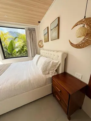 a bedroom with a white bed and a window at Calalun in Fortuna