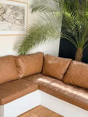 a brown leather couch in a living room with a plant at Calalun in Fortuna