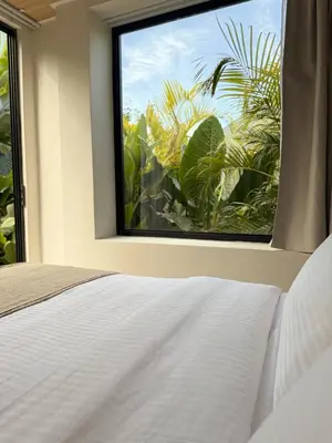 a bedroom with a window with a view of palm trees at Calalun in Fortuna