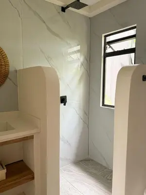 a bathroom with white marble walls and a window at Calalun in Fortuna