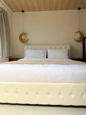 a large white bed with two pillows on it at Calalun in Fortuna