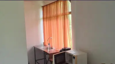 a bathroom with a sink and a window with an orange curtain at Mountain Retreat in Bijagua de Upala with Stunning Nature Views in Bijagua