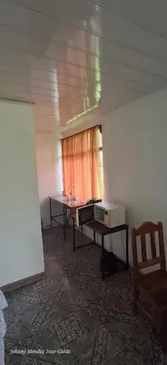 a room with a desk and a table with a window at Mountain Retreat in Bijagua de Upala with Stunning Nature Views in Bijagua