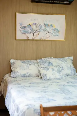 a bed with pillows and a painting on the wall at Villa Azul-Colibrí, Río Celeste in Rio Celeste