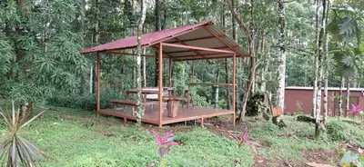 a wooden pavilion with a table in the middle of a forest at Villa Azul-Colibrí, Río Celeste in Rio Celeste