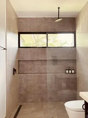a bathroom with a shower with a toilet and a window at Casa Celeste in Uvita