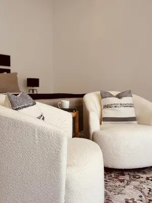 a living room with two white chairs and a table at Casa Celeste in Uvita