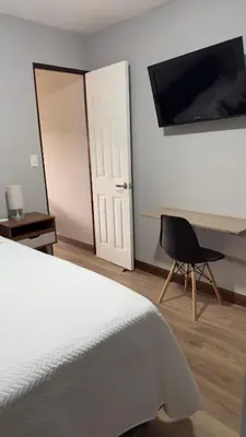 a bedroom with a bed and a desk and a chair at Central and comfortable mini apartment in San Sebastian in San José