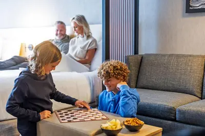 a boy and a girl playing chess in a living room at Hyatt Place Cariari/Convention Center in San José