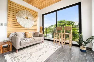 a living room with a couch and a large window at TH5 Peaceful Surf Retreat Walk to Beach and Town in Tamarindo