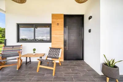 a porch with a wooden door and a table and chairs at TH5 Peaceful Surf Retreat Walk to Beach and Town in Tamarindo