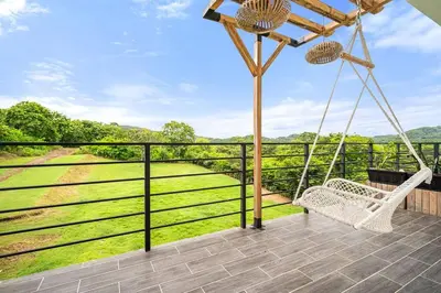 a porch with a swing and a view of a field at TH5 Peaceful Surf Retreat Walk to Beach and Town in Tamarindo