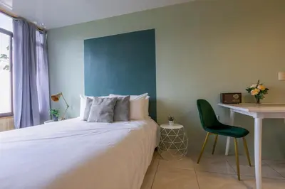 a bedroom with a bed and a desk and a chair at Lovely Loft with volcan view La Fortuna Downtown in Fortuna