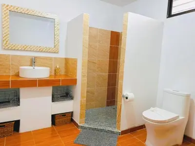 a bathroom with a toilet and a sink and a mirror at Casa Colibri Tropical Ocean View 5 min to Beach in Nicoya