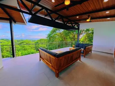 a large living room with couches and a balcony at Casa Colibri Tropical Ocean View 5 min to Beach in Nicoya