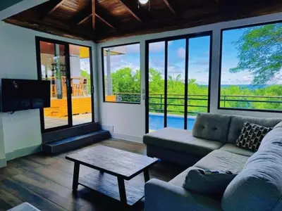 a living room with a couch and a table at Casa Colibri Tropical Ocean View 5 min to Beach in Nicoya