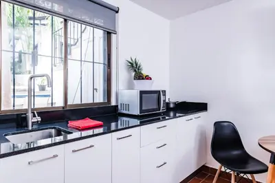 a kitchen with a sink and a microwave at Hotel Gardenia Tamarindo in Tamarindo