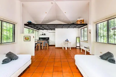 an attic room with two beds and a kitchen at Hotel Gardenia Tamarindo in Tamarindo