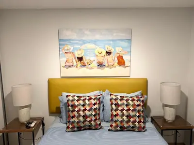 a bedroom with a bed with a painting on the wall at Vistas del Bosque Jacó in Jacó