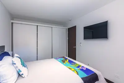 a bedroom with a bed and a flat screen tv at Relaxing Beach Oasis - Gated Community with Pool - Mini Golf - Walking Distance to Beach in Jacó