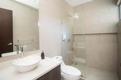 a bathroom with a sink and a toilet and a shower at Relaxing Beach Oasis - Gated Community with Pool - Mini Golf - Walking Distance to Beach in Jacó
