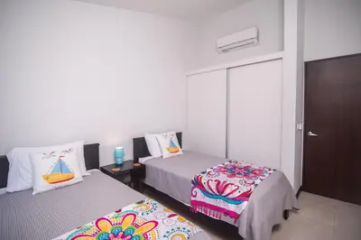 a bedroom with two beds and a closet with a door at Relaxing Beach Oasis - Gated Community with Pool - Mini Golf - Walking Distance to Beach in Jacó