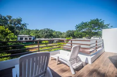 two chairs sitting on the deck of a house at Relaxing Beach Oasis - Gated Community with Pool - Mini Golf - Walking Distance to Beach in Jacó