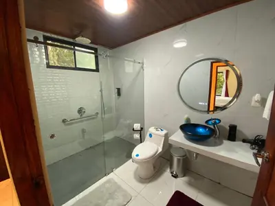 a bathroom with a shower and a toilet and a sink at Monteverde Beaumont in La Cruz