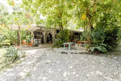 a house with a table and chairs in front of it at Bajo el Arbol B&B in Santa Teresa Beach